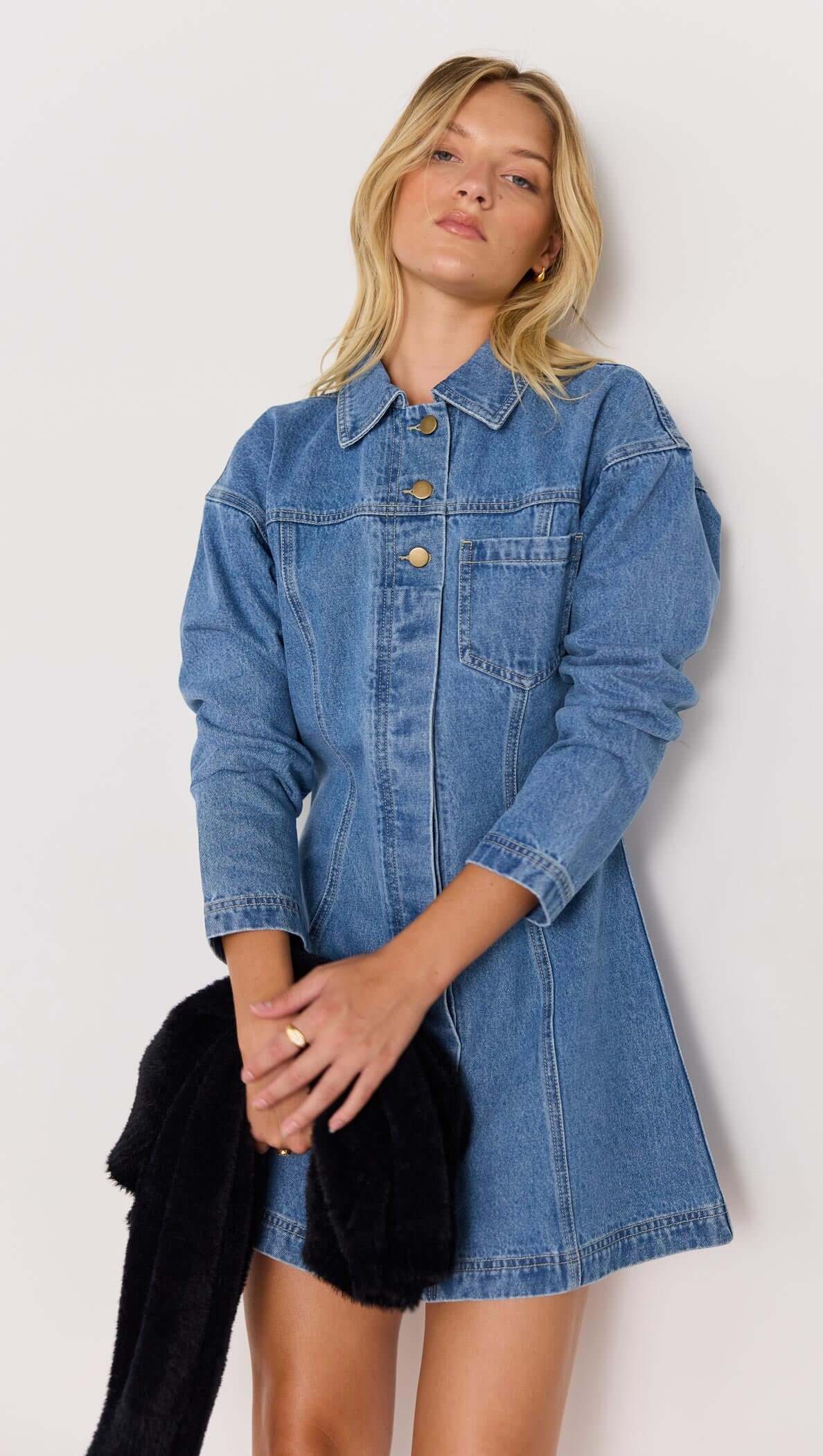 Model wearing the Tully Denim Mini Dress in vintage blue, featuring a collared neckline and snap front closure.