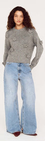 Model wearing Round Neck Grey Floral Applique Jumper with relaxed fit, paired with light blue wide-leg jeans.