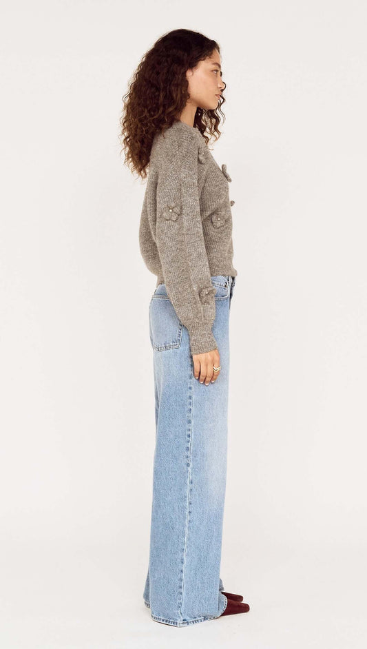 Round Neck Grey Floral Applique Jumper styled with light blue jeans in a side view.