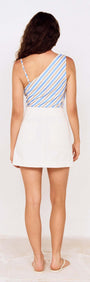 Back view of a model wearing a striped top and a White Denim High Rise Mini Skirt.