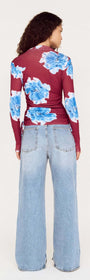 Back view of blue floral mesh long sleeve top paired with wide-leg jeans on a model.