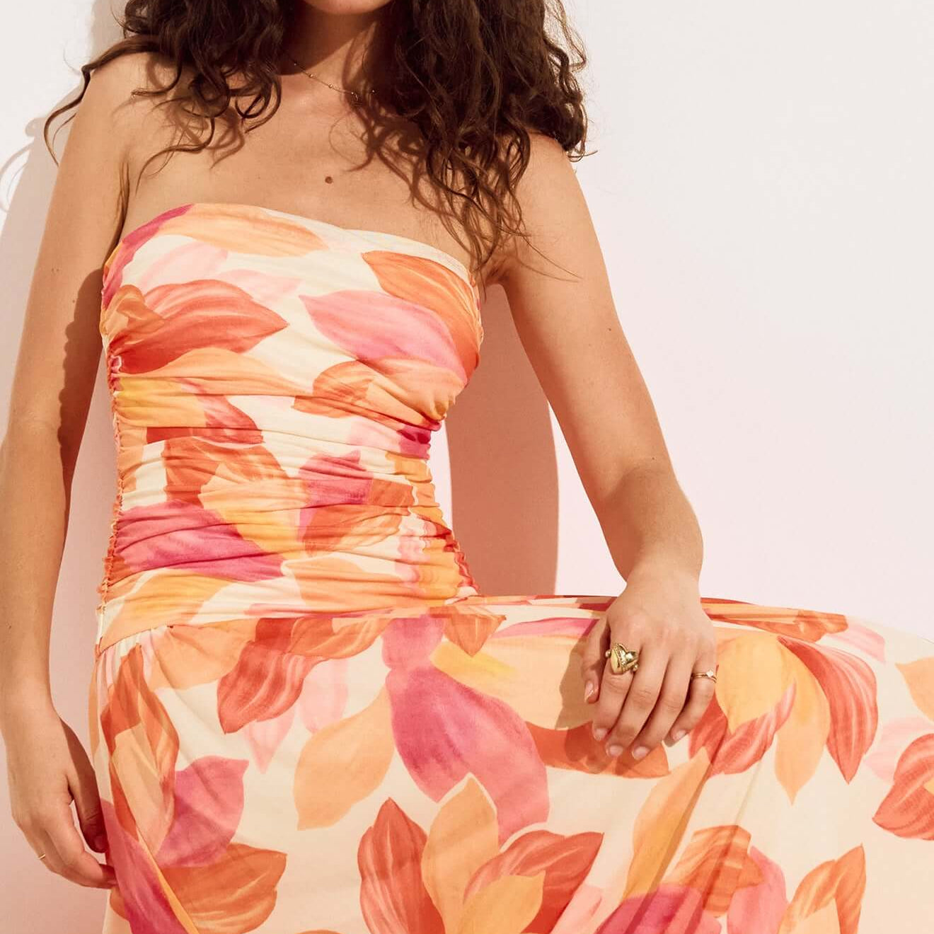 Sunset Leaf Print Sleeveless Midi Dress showcased by a model with curly hair in a tropical floral pattern.