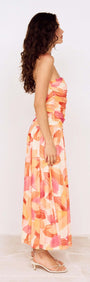 Side view of a model wearing a Sunset Leaf Print Sleeveless Midi Dress with a vibrant tropical print.
