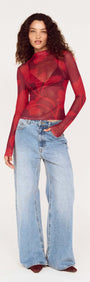 Model wearing an Oversized Floral High Neck Mesh Top with long sleeves, paired with wide-legged jeans, showcasing a stylish look.