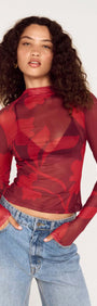 Model wearing an Oversized Floral High Neck Mesh Top in red floral print with long sleeves.