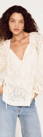 Model wearing Cream Broderie Baloon Sleeve Blouse featuring delicate lace and balloon sleeves, paired with jeans.