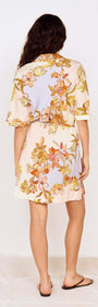 Back view of a woman in a Pastel Floral Mini Shirt Dress showcasing floral patterns and relaxed fit.