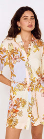Woman wearing a stylish Pastel Floral Mini Shirt Dress with oversized florals and a collared neckline.