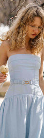 Model wearing a Baby Blue Drop Waist Midi Dress with Belt Detail holding an ice cream cone outside.