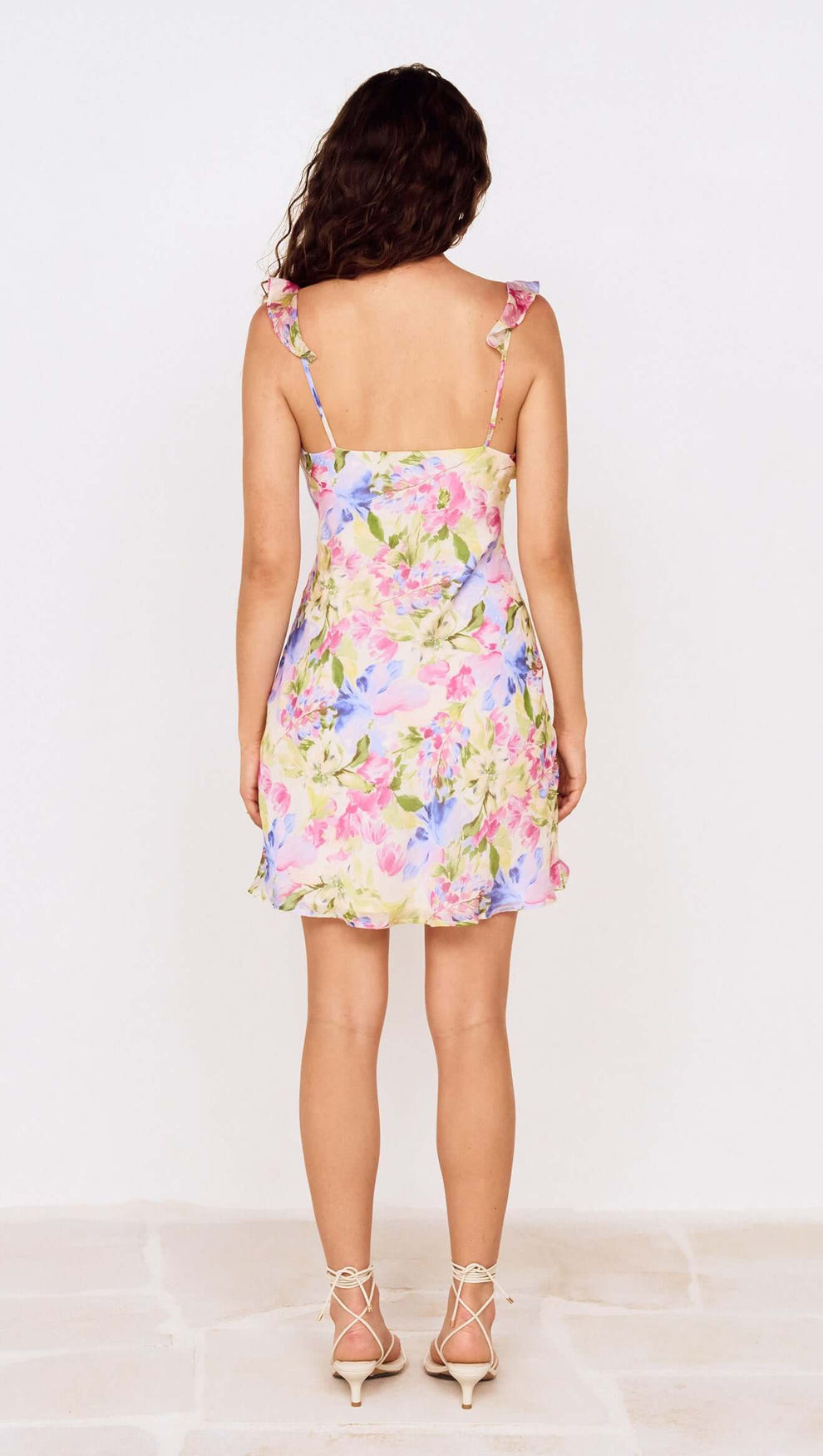 Back view of Watercolour Floral Mini Dress with Frill Trim featuring colorful floral design and adjustable straps.