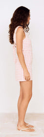 Pink Gingham Tie Back Cotton Mini Dress worn by a model showing side view, showcasing its playful gingham pattern.