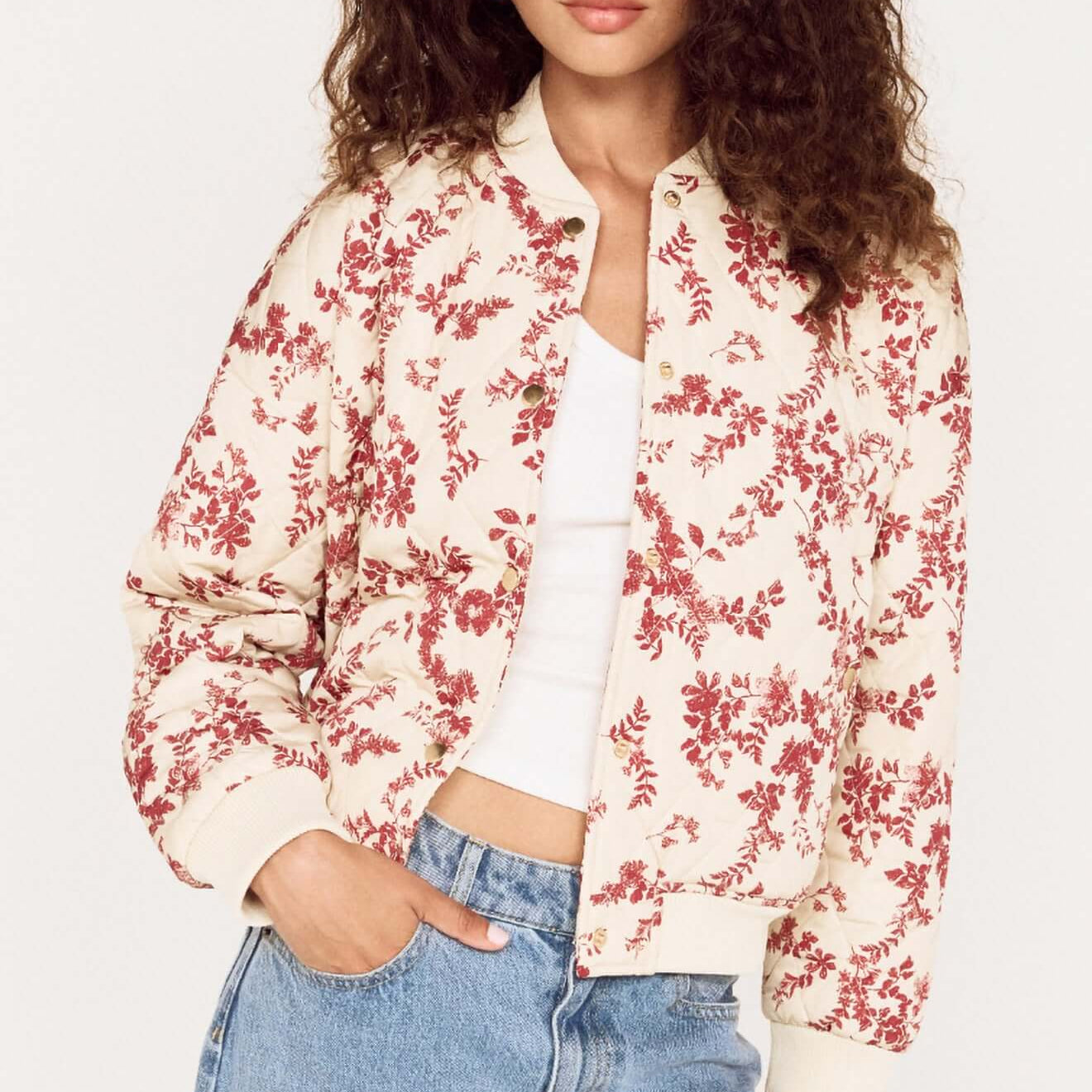 Model wearing the Autumn Floral Quilted Puffer Jacket with a floral pattern and casual jeans, showcasing a stylish fall look.