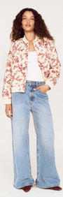 A woman wearing an Autumn Floral Quilted Puffer Jacket with wide-leg jeans, showcasing a stylish autumn look.