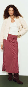 Model wearing a Quilted Bomber Jacket in Warm White paired with a striped skirt, showcasing a trendy outfit.