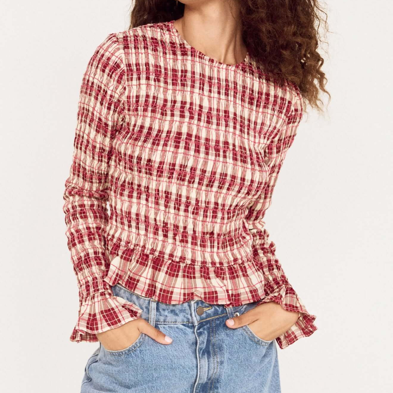 Model wearing a Frill Detail Check Print Shirred Top paired with denim jeans, showcasing a stylish, casual look.