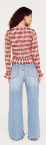 Back view of model wearing the Frill Detail Check Print Shirred Top with wide-leg jeans, showcasing the stylish check print design.