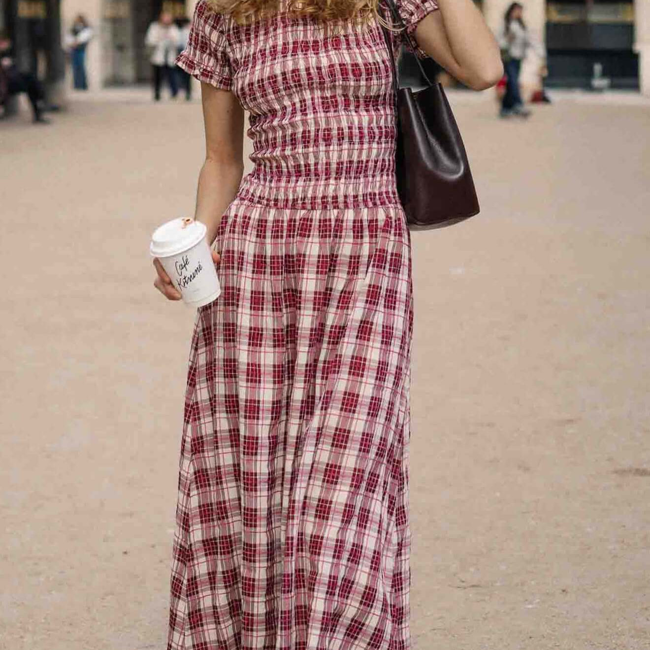 Short Sleeve Shirred Check Midi Dress worn by a woman holding a coffee cup in a park setting with stylish accessories.