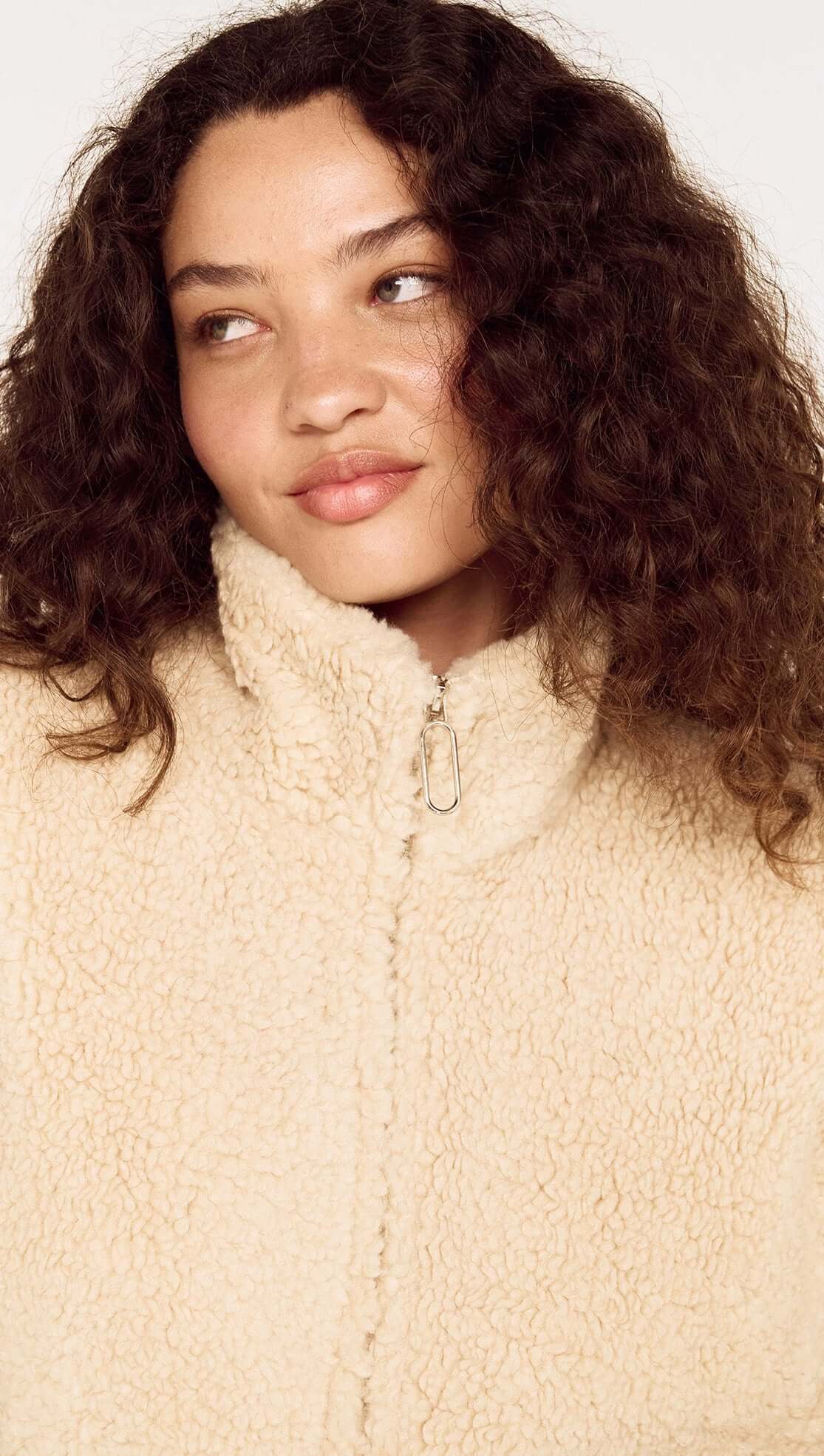 Beige Teddy Jacket with High Collar worn by a model with curly hair, showcasing a cozy winter look.