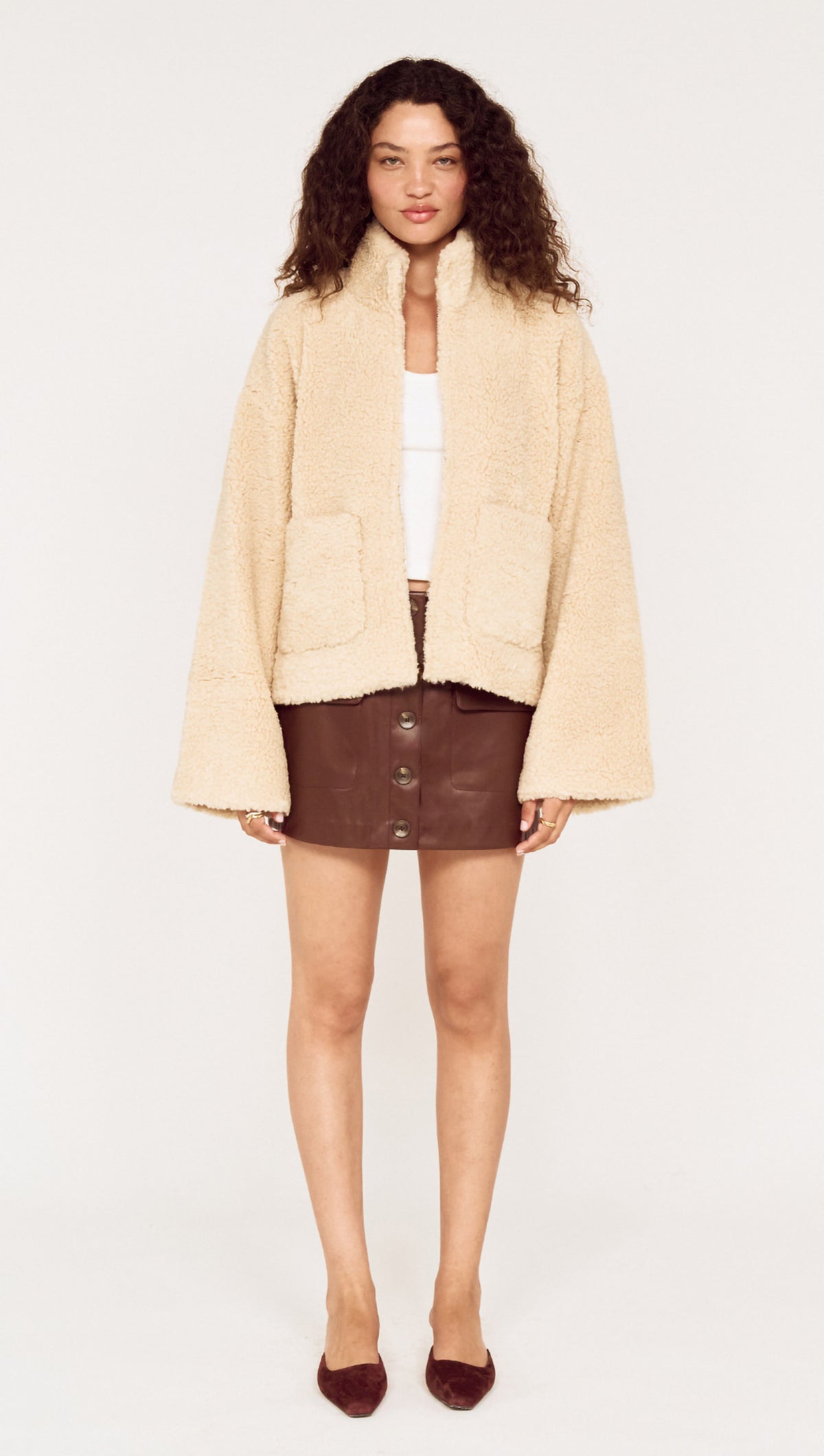 Beige Teddy Jacket with High Collar style worn with a brown leather skirt, ideal for stylish winter outfits.