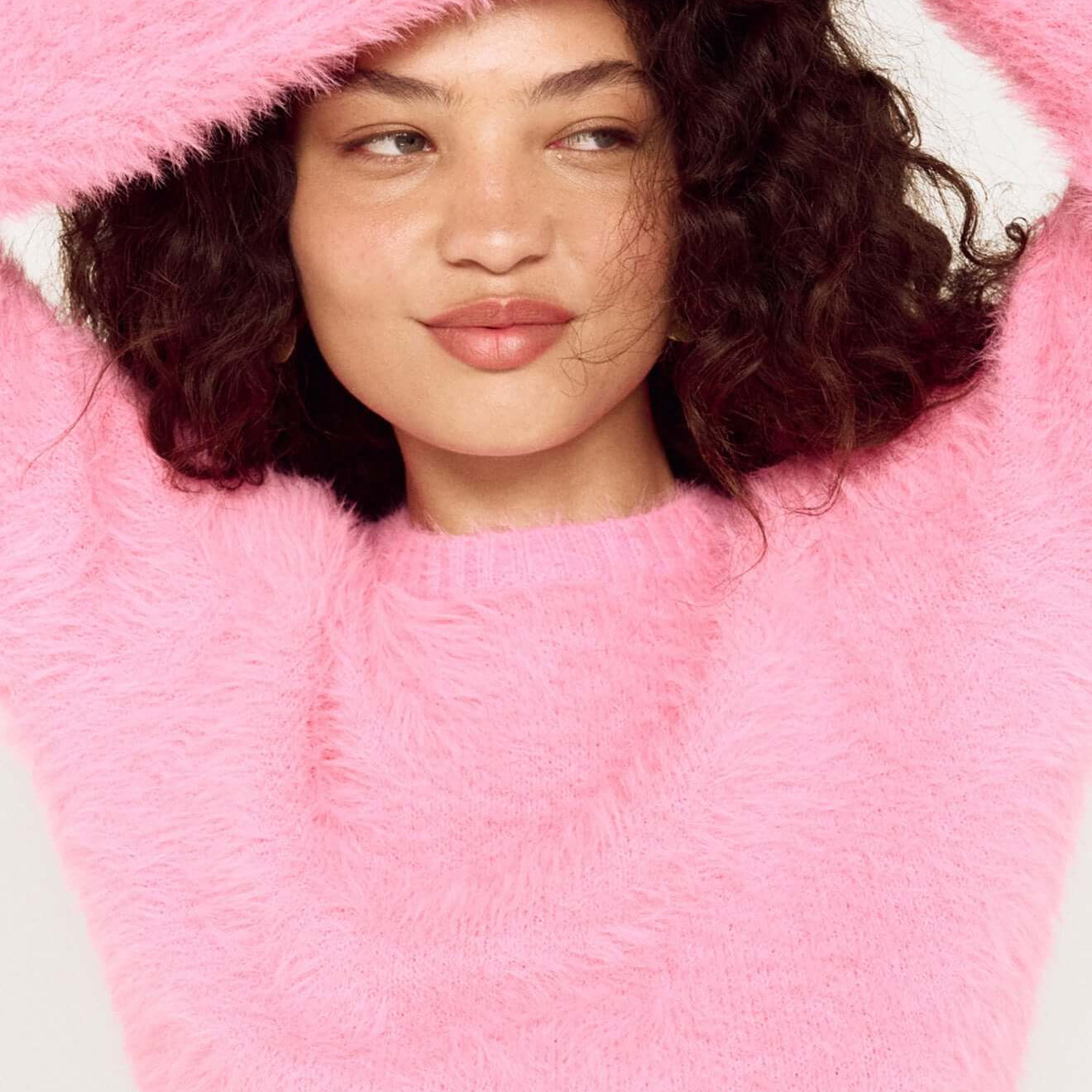 Clio Cropped Fuchsia Pink Fluffy Jumper modeled by a woman with curly hair, showcasing the soft texture and vibrant color.