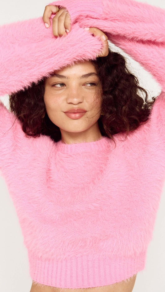 Clio Cropped Fuchsia Pink Fluffy Jumper modeled by a woman with curly hair, showcasing the soft texture and vibrant color.