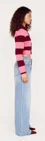 Model showcasing the Pink Stripe Pointelle Knit Cardi in pink and burgundy stripes, styled with high-waisted jeans.