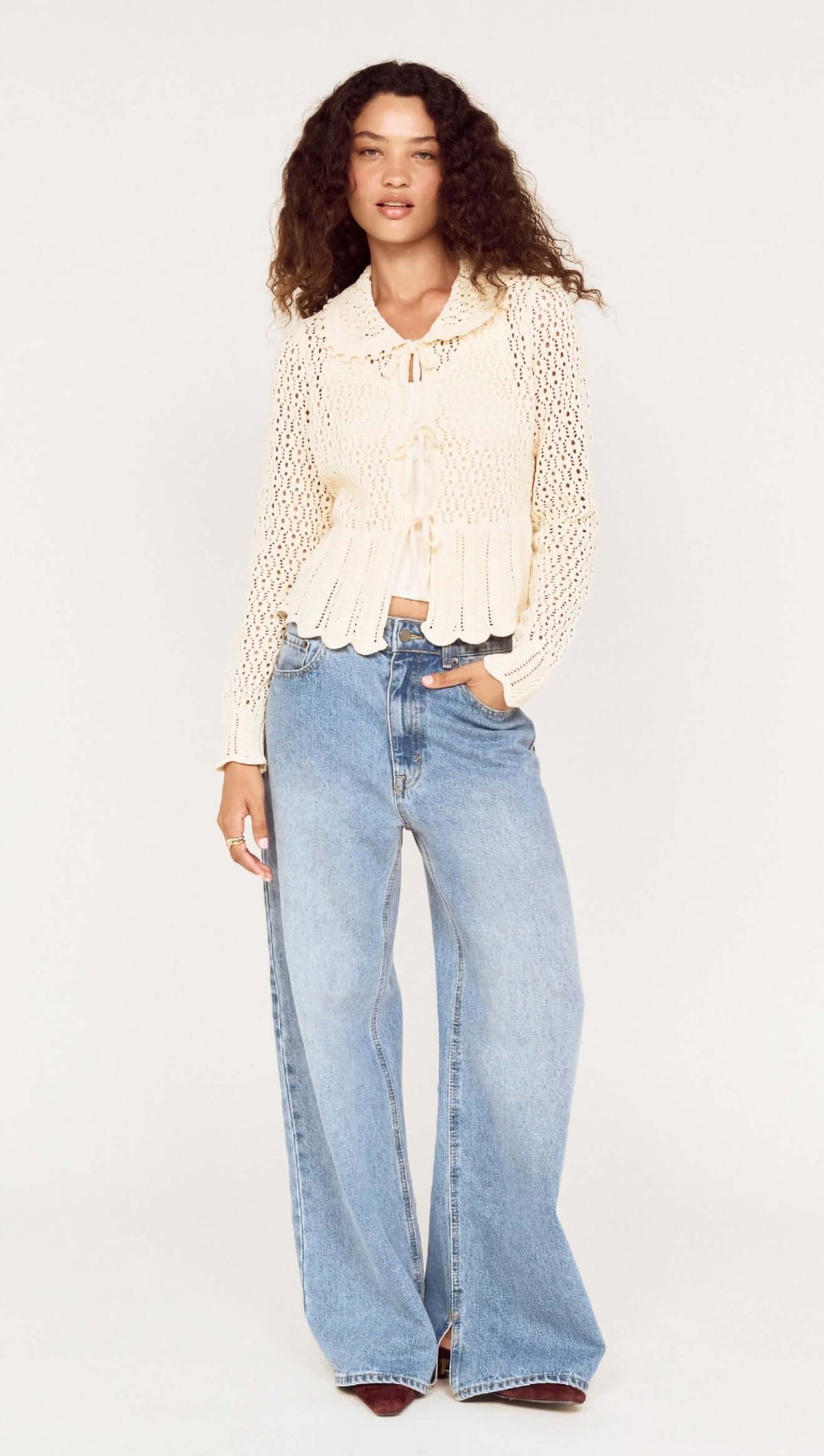 Model wearing a Cream Pointelle Knit Cardi with Tie Front styled with wide-leg jeans.