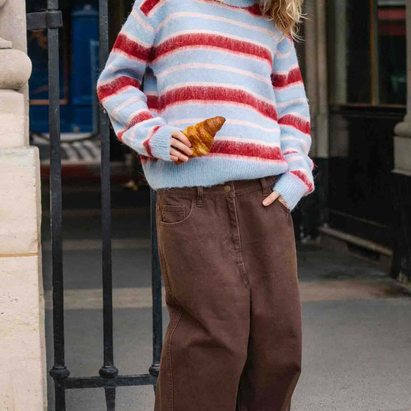 Peppermint Stripe Fluffy Jumper worn by a model outside, featuring bold red and blush stripes on a soft blue background.