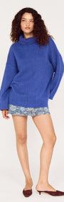 Model wearing a Blue Oversized Roll Neck Jumper with shorts, showcasing a cozy and stylish look.