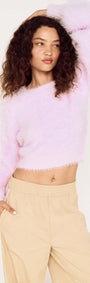 Model wearing a Cropped Baby Pink Fluffy Jumper paired with light pants, showcasing a stylish, comfortable look.