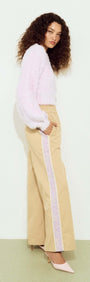 Model wearing a Cropped Baby Pink Fluffy Jumper paired with wide-leg beige trousers.