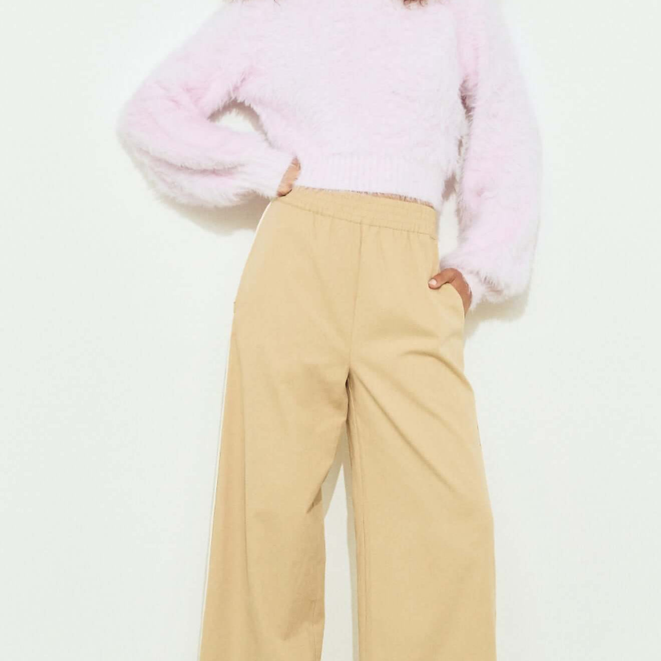 Cropped Baby Pink Fluffy Jumper styled with wide-leg beige pants and high heels, showcasing a chic, casual look.