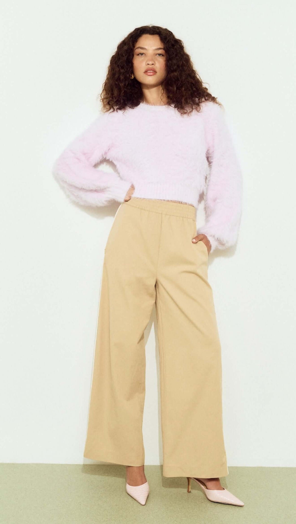Cropped Baby Pink Fluffy Jumper styled with wide-leg beige pants and high heels, showcasing a chic, casual look.