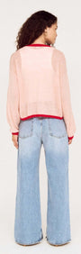 Back view of a model wearing the Sheer Contrast Trim Pink Cardigan with wide-leg jeans.