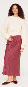 Model wearing a Cream Relaxed Fit Cable Knit Jumper with a striped skirt for a stylish winter outfit.