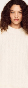 Cream Relaxed Fit Cable Knit Jumper worn by a model, showcasing its relaxed silhouette and classic crew neckline.