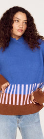 Model wearing a cobalt blue intarsia detail jumper with playful patterns in brown and pink.