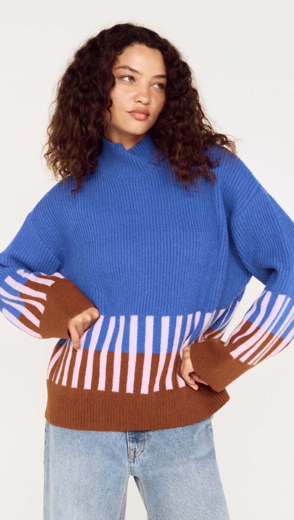 Model wearing a cobalt blue intarsia detail jumper with playful patterns in brown and pink.