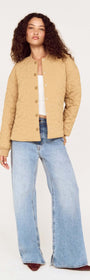 Beige Floral Quilted Puffer Jacket worn by a model, featuring a quilted design and relaxed fit, styled with wide-leg jeans.