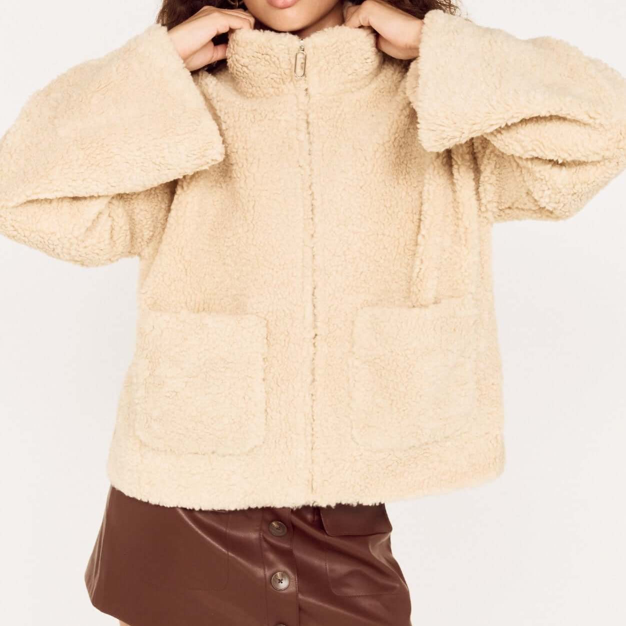 Woman wearing a Beige Teddy Jacket with High Collar over a brown skirt, showcasing a stylish winter outfit.