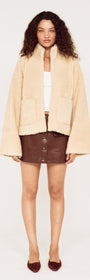 Beige Teddy Jacket with High Collar style worn with a brown leather skirt, ideal for stylish winter outfits.