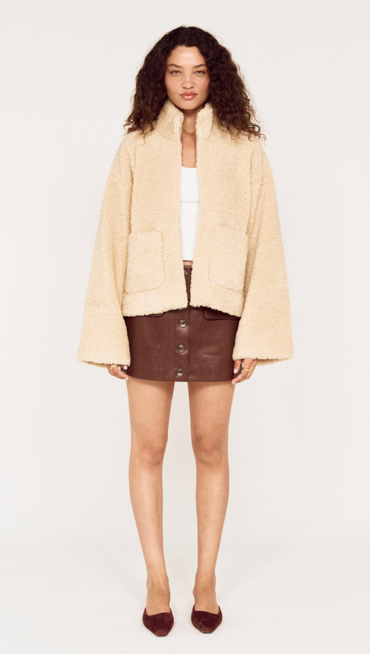 Beige Teddy Jacket with High Collar style worn with a brown leather skirt, ideal for stylish winter outfits.