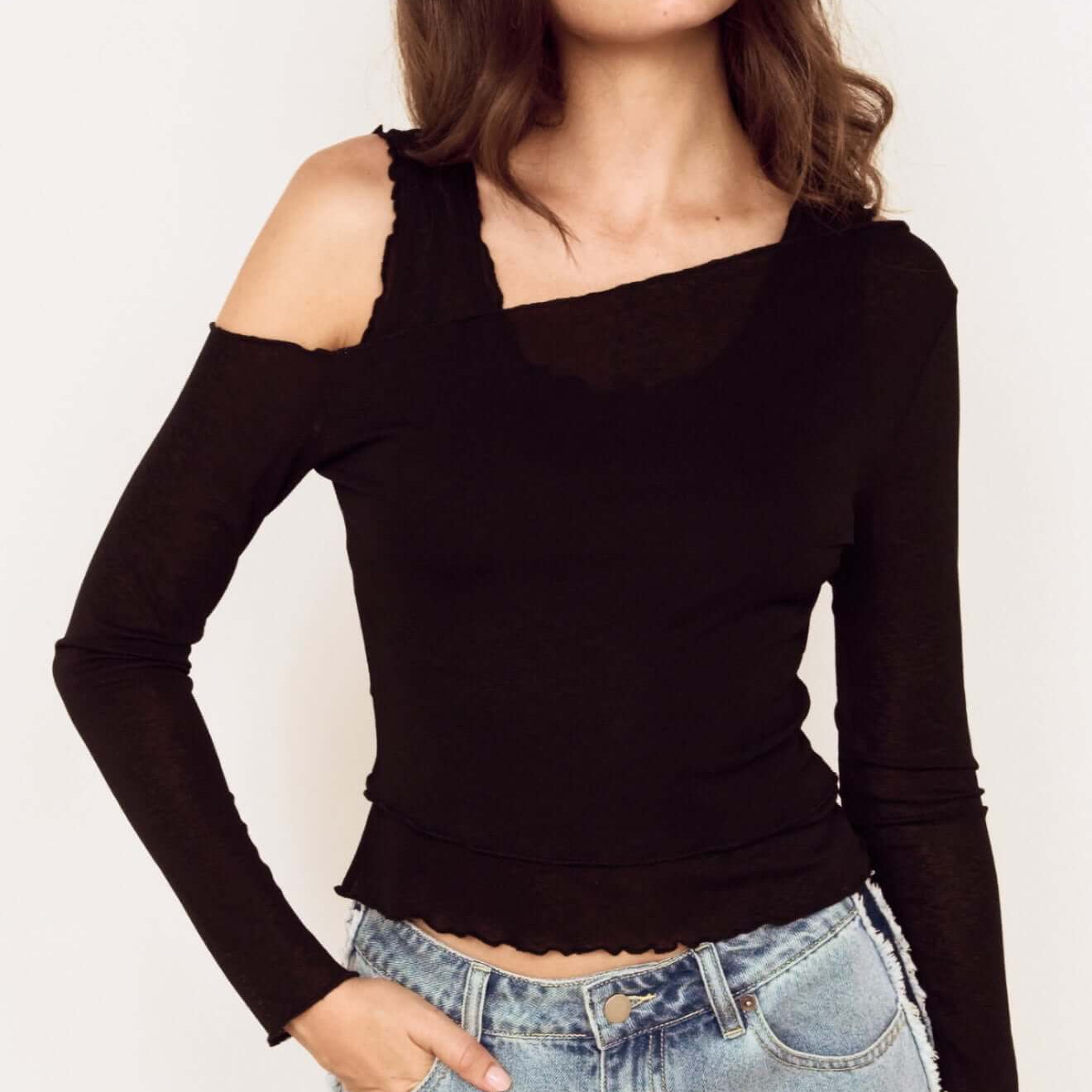 Model wearing a Black Asymmetric Layered Mesh Top with denim jeans, showcasing its stylish design and cropped hem.