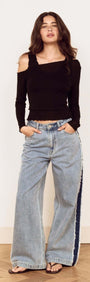 Model wearing Black Asymmetric Layered Mesh Top with wide leg jeans and sandals.