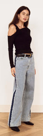 Model showcasing the Black Asymmetric Layered Mesh Top paired with trendy wide-leg jeans.