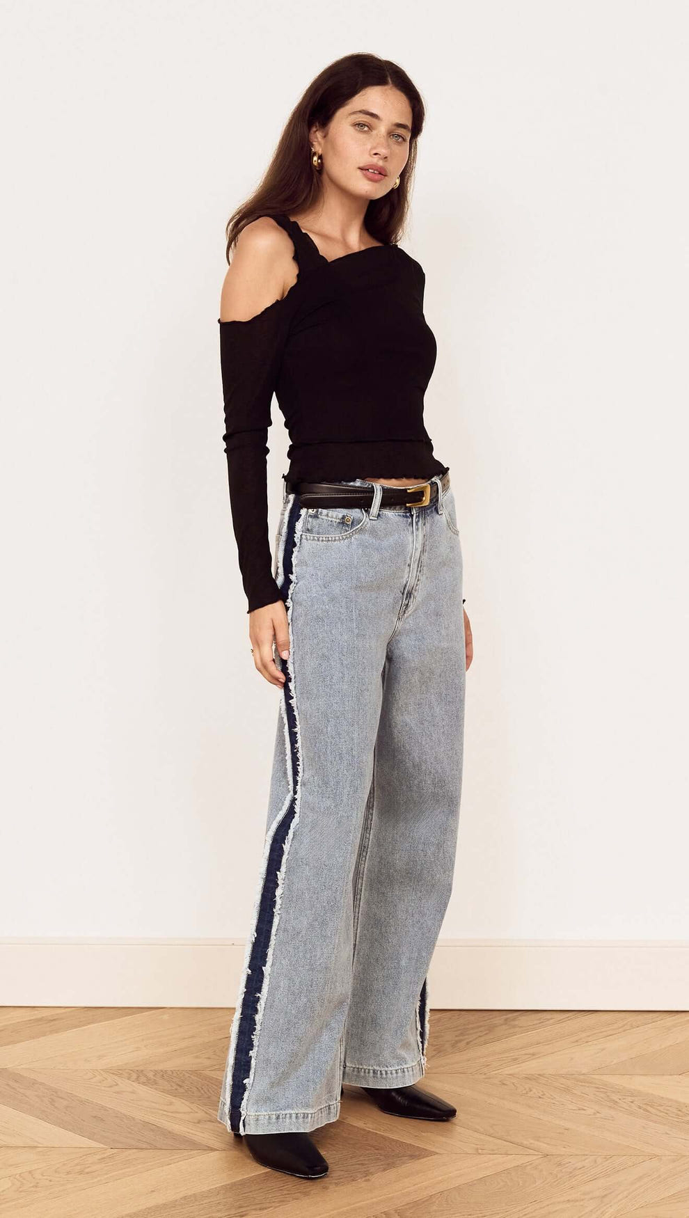 Model showcasing the Black Asymmetric Layered Mesh Top paired with trendy wide-leg jeans.