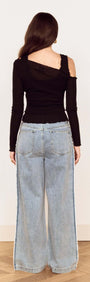 Back view of model wearing Black Asymmetric Layered Mesh Top paired with wide-leg jeans.