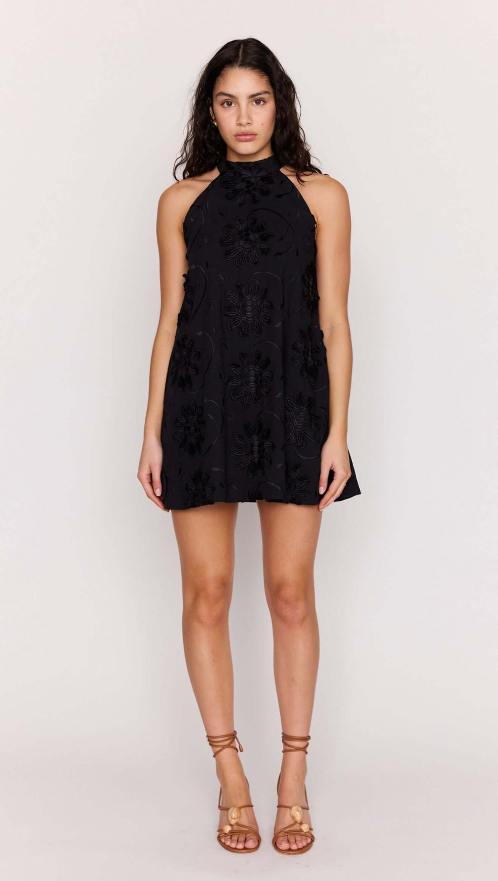 Black Cotton Applique High Neck Mini Dress worn by model, showcasing its floral design and halter neckline.