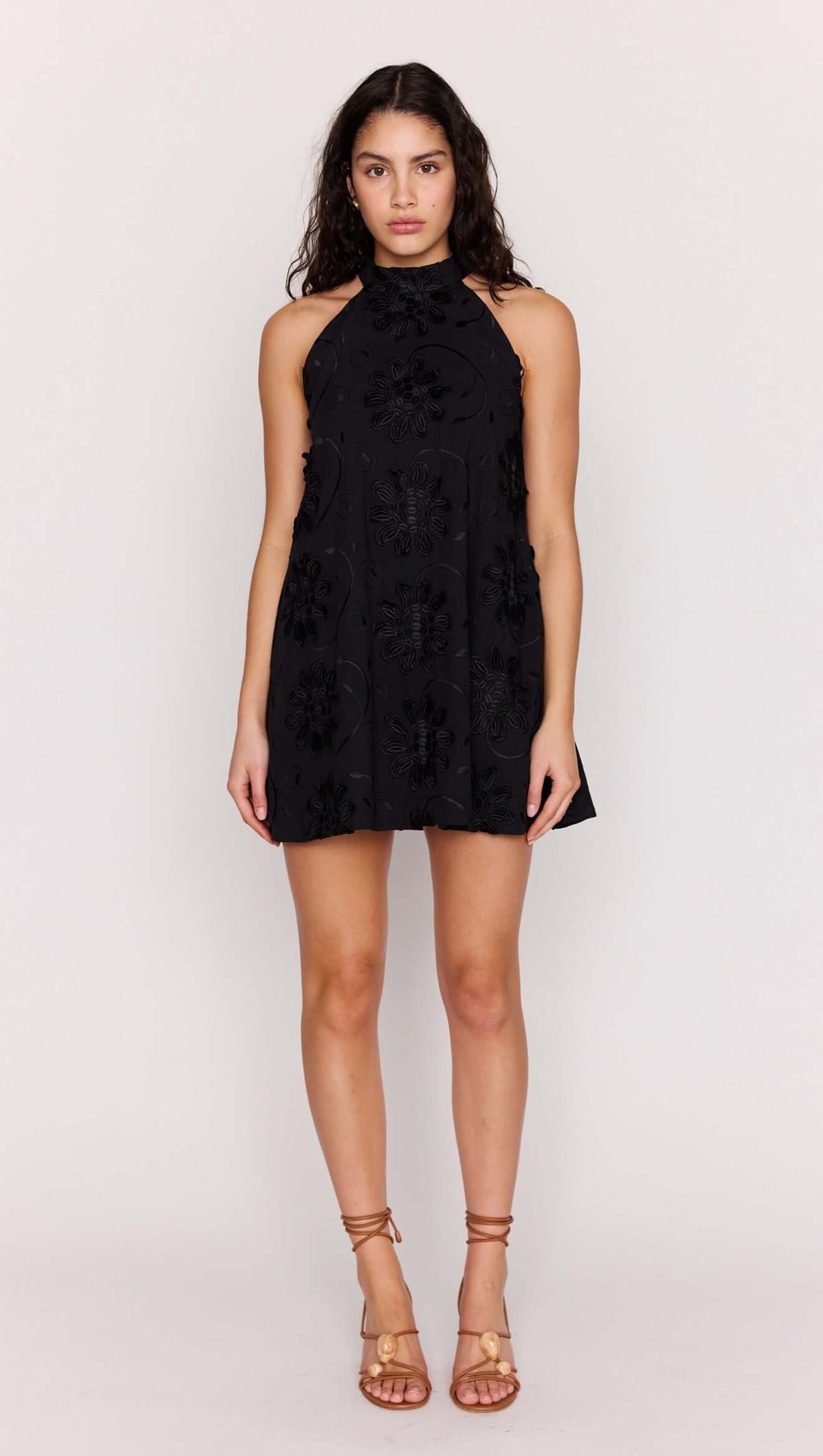 Black Cotton Applique High Neck Mini Dress worn by model, showcasing its floral design and halter neckline.