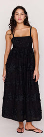 Black Tiered Cotton Applique Midi Dress worn by a model, showcasing elegant floral detailing and a flowing silhouette.